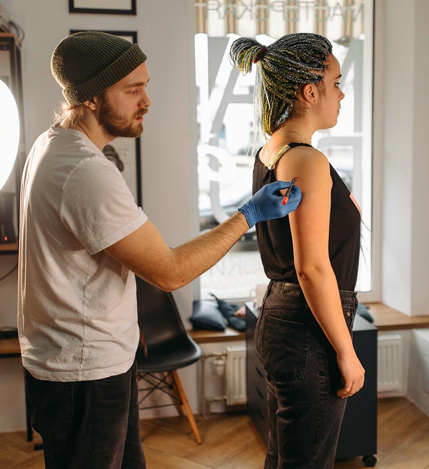 Tattoo Artist Applying Stencil on Woman Tattoo Artist Applying Stencil on Woman