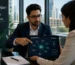 A Generative Engine Optimization specialist presenting a brand entity relationship graph and AI citation network to a client on a tablet in a modern office.